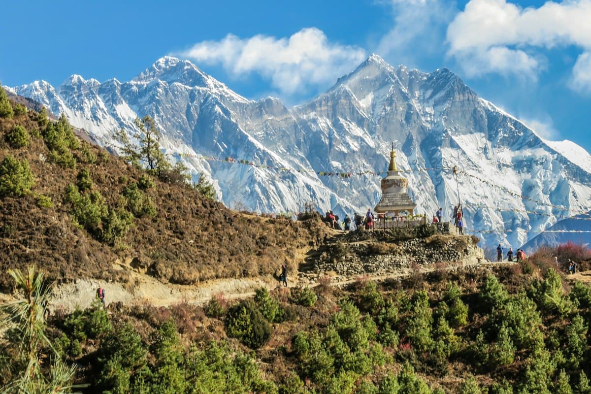 Trekkers on a mountain trail with snowy peaks
